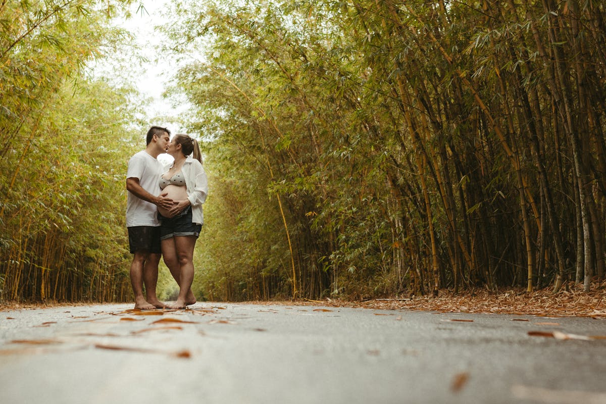 Casal abraçado com as mãos na barriga da mulher, simbolizando união e planejamento familiar durante o período fértil